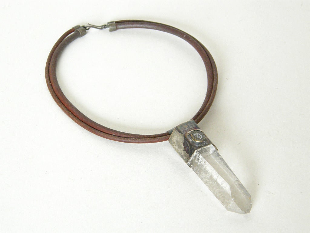 This primitive, yet modern, necklace by Chicago jeweler Ted Drendel has a mystical quality. The pendant features a large, natural rock crystal (quartz) in a sterling mount set with a spiral shell fossil. It hangs from double, rounded  leather cords.