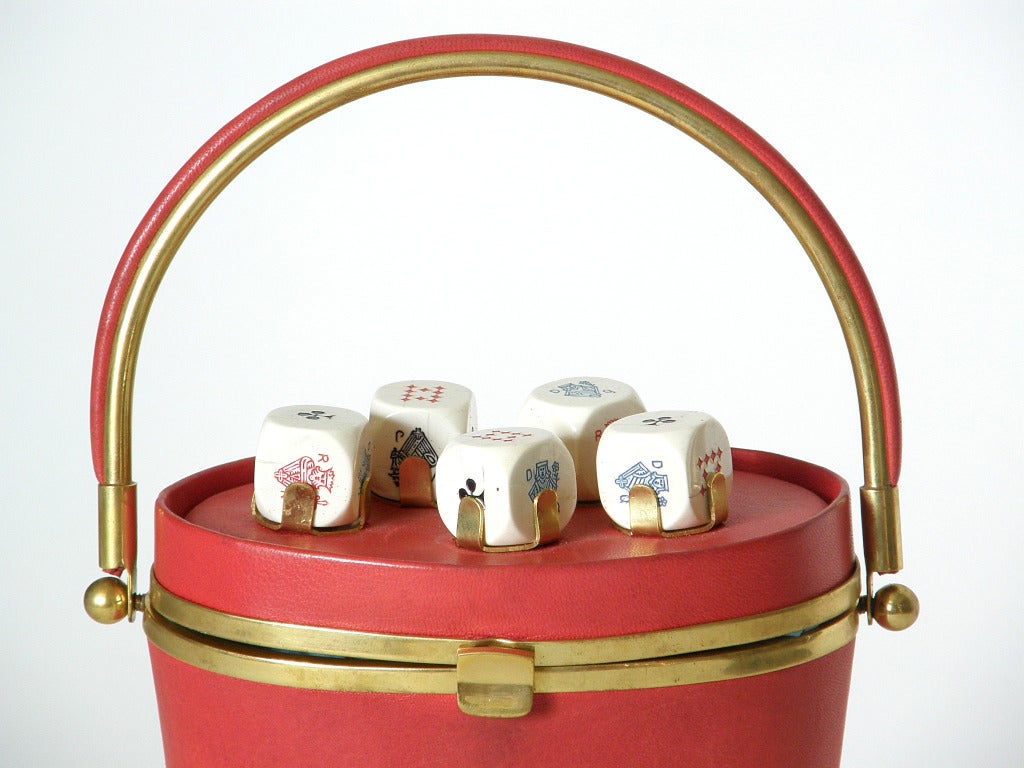 Very rare poker dice handbag by Anne-Marie. The bag is covered in red leather with gold-plated brass brackets that hold actual poker dice on the lid. The poker dice can be removed for a bit of gambling when the mood strikes, then returned to