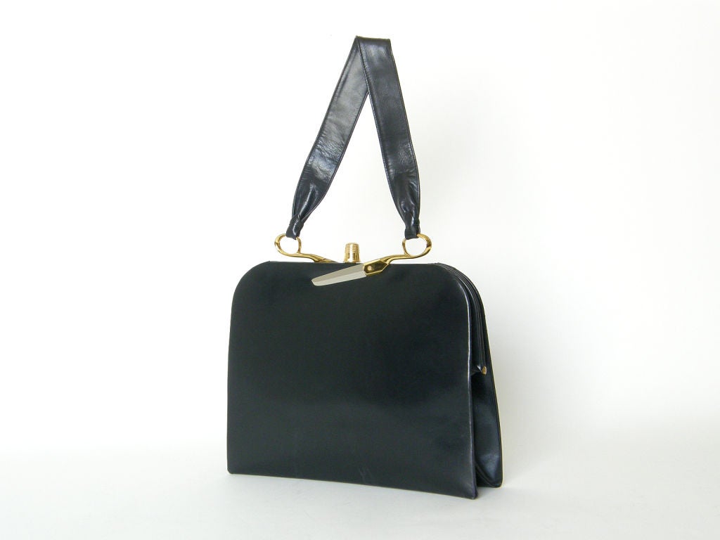 This exceptional Koret black leather handbag handbag has dissected scissors attaching the handle to the frame and a thimble for the clasp. The gold plated thimble and gold and silver plated scissors halves are extremely realistic. The black leather