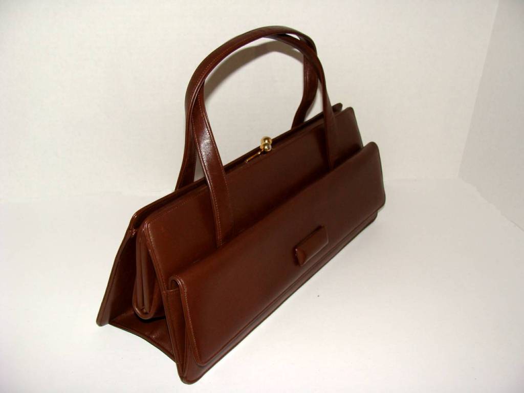 This is an amazing couture handbag made in Florence.  Designed by Nettie Rosenstein, the leather interior is beautifully fitted and also has a bonus exterior pocket which runs the full length of the bag.

The brown is a rich milk chocolate brown. 