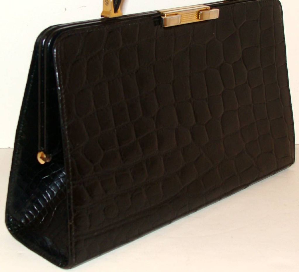 Large structured crocodile handbag with structured handle that allows wearer to tuck under shoulder.  The handle drop is 6