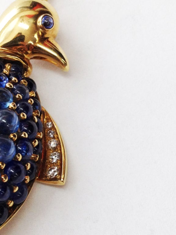 Delightful Penguin Brooch/Pendant encrusted with (39) Vivid Blue Cabochon Sapphires  wing enhanced with five round full cut diamonds, 18k Yellow Gold  Marked: ITALY 750 18Kt City mark: AL corresponds to: Alessandria.  Adorable…must have!