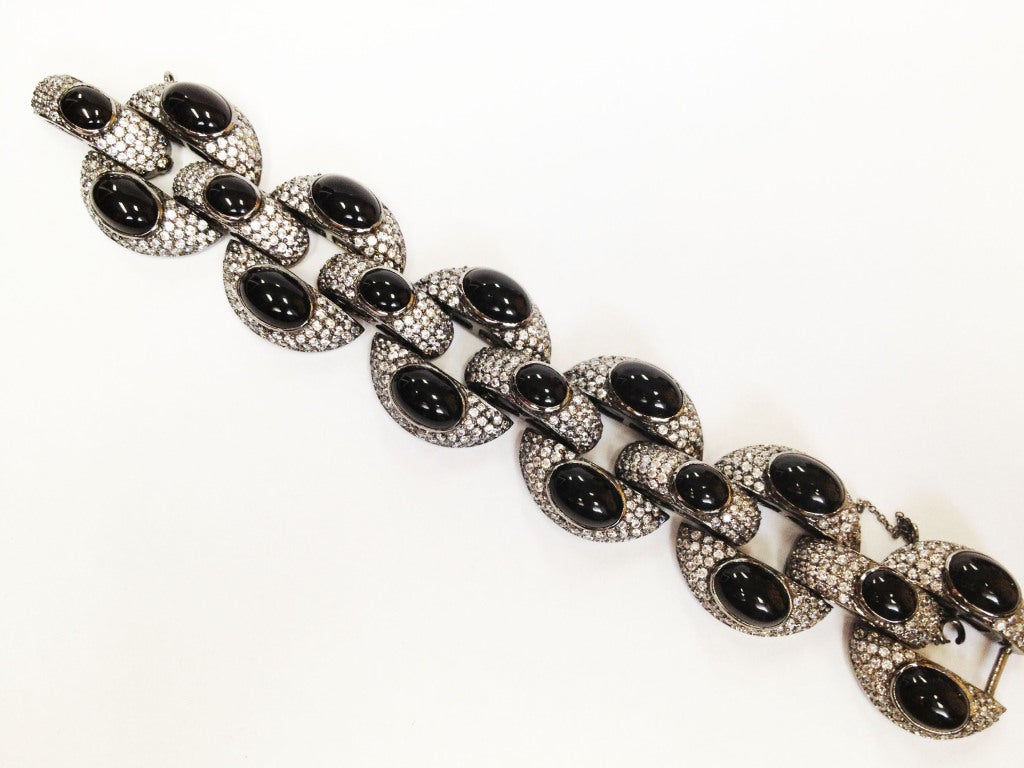 Alluring and striking Chunky black rhodium, gunmetal finish brass link bracelet; each link encrusted with Swarovski crystals and also set with black cabochon onyx; approx. length 8 in.; link size 1.25 in. in diameter. Approx. length with one