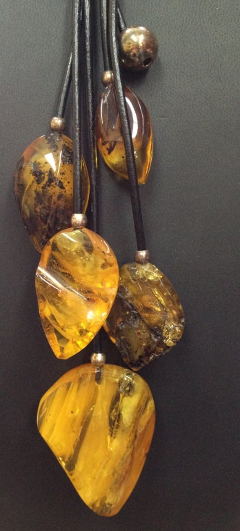Beautiful Cascade of graduated, polished Natural Amber and S/S accents, serves as the focal point for this handcrafted  necklace on leather. Amber ranging in size from 30.5mm x 21.5mm to 61mm x 46mm Sterling silver beads and spacers accent the