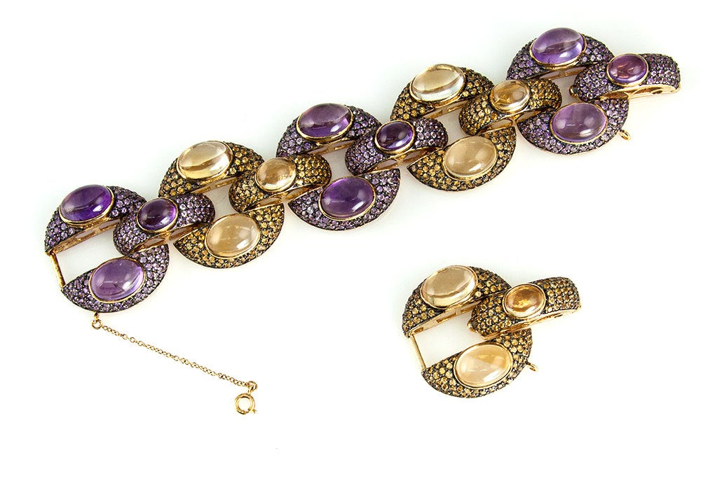 Alluring and striking Amethyst and Citrine Link Bracelet; each link encrusted with genuine facet-cut and genuine cabochon Amethyst and Citrine gems; Mounted in gilded brass. Approx. length 8 inches; link size 1.25 inch diameter; approx. length with