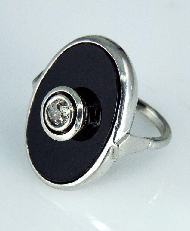 Beautiful classical elegance; designed and hand crafted in 14k White Gold; this Runway Ring hallmarks the characteristics of the famed Art Deco period, the central tablet of black Onyx showcases a sparkling exquisite double bezel-set with an old