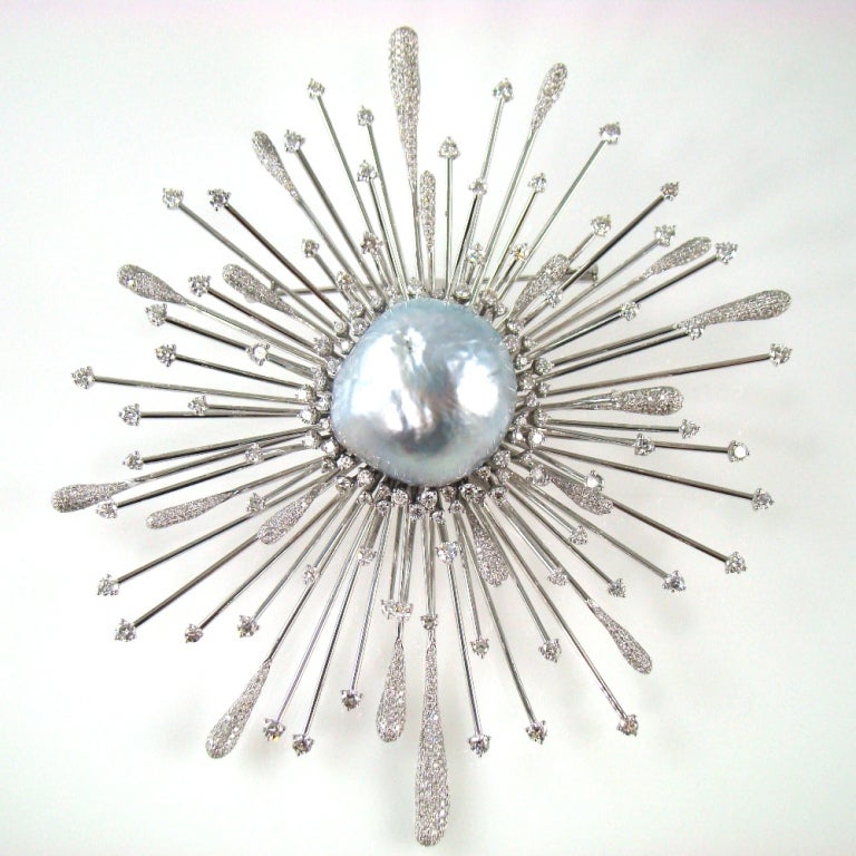 Spectacular Star Burst Brooch center set with a silvery grey high luster, natural color South Sea Baroque Pearl measuring approx. 22.5mm x 25mm and 1160 Diamonds, weighing approx. 8.07ct; mounted in 18k white gold; handmade. Measuring approx. 4