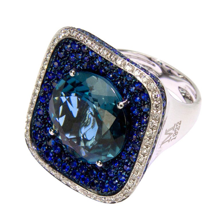 Beautiful Blue Cluster ring, centering a large round brilliant-cut Swiss Blue Topaz surrounded by round brilliant-cut Blue Sapphires weighing approximately 2.75 carats and brilliant-cut diamonds, on outer border,  weighing approximately 0.37 carats;