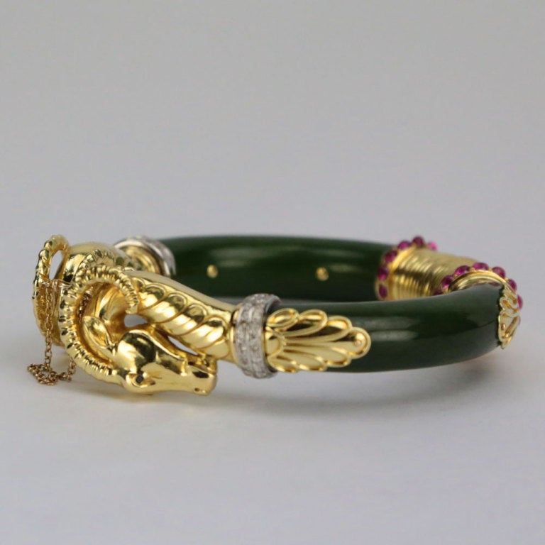 Beautiful Double Ram's Head 14k yellow gold and Jade Bangle Bracelet, set with twenty-eight natural oval cabochon rubies and sixty-four round brilliant-cut; approx. total diamond weight: 1 ct; SI1; color: G-H brilliant-cut diamonds. Marked on clasp: