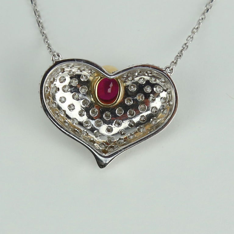 Simply Beautiful! Finely detailed Ruby Heart and Diamond Necklace. Centering a securely nestled Hand set Fabulous Heart shaped Ruby. Surrounded by round Brilliant-cut Diamonds. Hand crafted in 18K Yellow and White Gold mounting. More Beautiful in