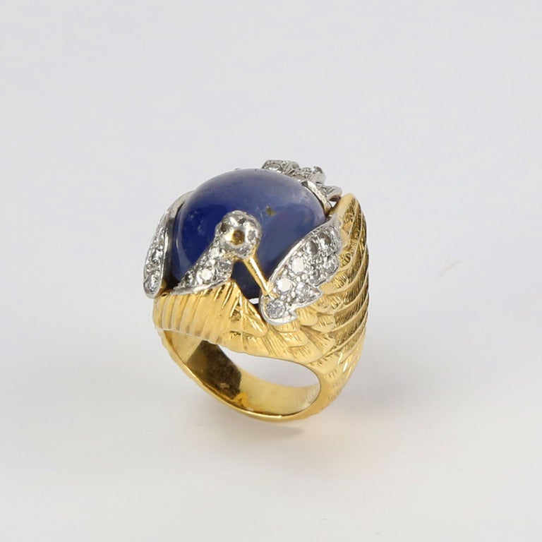 Amazing and unusual Gold Phoenix Ring, featuring a large Cabochon Sapphire, weighing approx. 35 Carat, accented by Round Brilliant-cut Diamonds, weighing approx. 1.10tcw. Hand crafted 18K Yellow Gold  mounting. Ring size 7 1/2-7 3/4, we offer ring