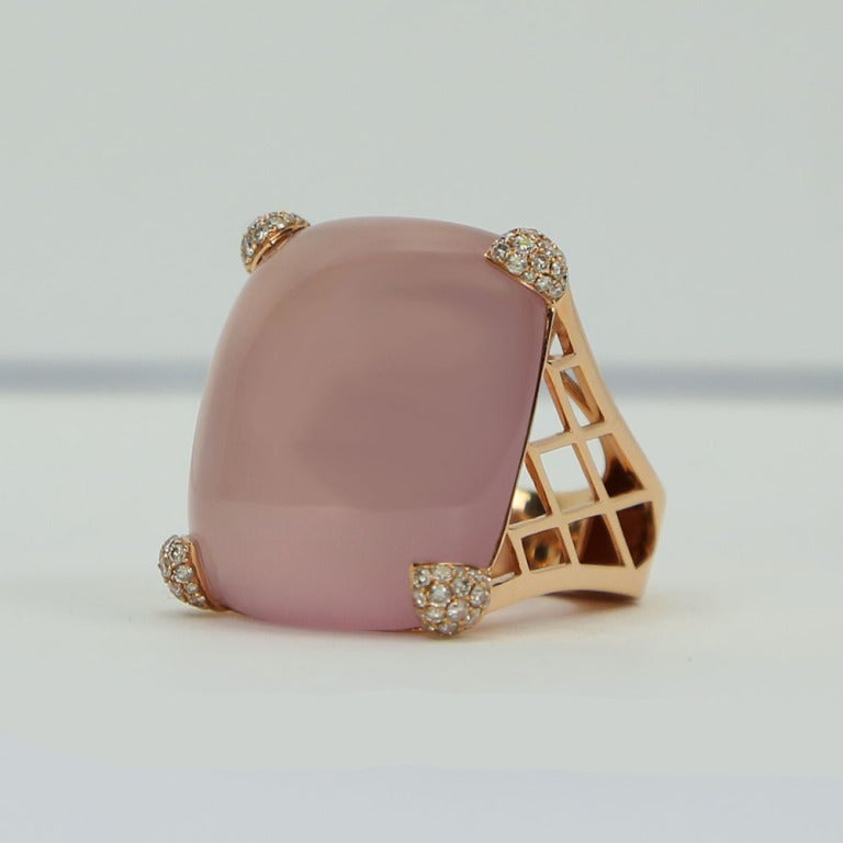 Simply Beautiful! Finely detailed Rose Quartz and Diamond Gold Cocktail Ring. Centering a large rectangular  65 Carat Cabochon Rose Quartz, Diamond set triangular-shaped prongs on 4 sides. Sixty-eight Diamonds, weighing approx. 0.68 total carats.