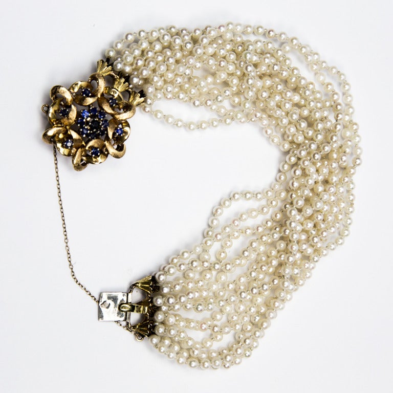 Beautiful 1940s Pearl Bracelet with shaped front clasp handmade in 18k yellow gold, set with fifteen round faceted Sapphires; comprising thirteen strands with a total of 630 pearls. Always in good taste, wear with pride!