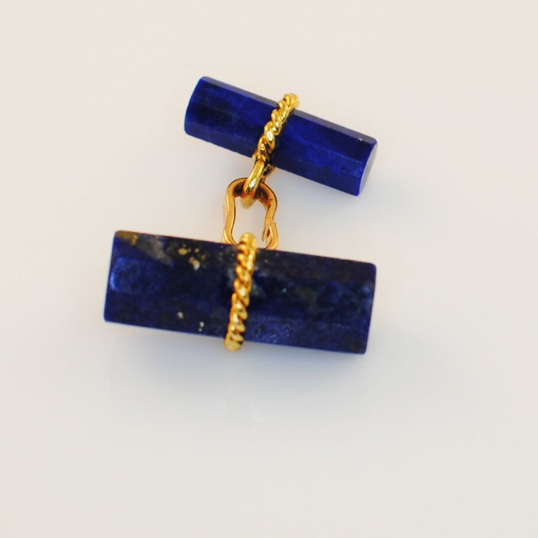 Exquisite set of Marchak Paris 18k yellow gold and Natural Lapis cuff links and studs, which use the pull pin method to go through the buttonholes.C1980s Approx. sizes: studs: 14mm x 5mm. cuff links fronts: 20mm x 7mm, and the rears: 16mm x 5mm;