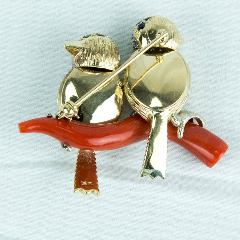 Beautiful pair of Birds perched on a Coral Branch; each set with Diamonds and Sapphires; bezel set ruby and sapphire in each eye; Fine Handmade detail in 14k yellow and white Gold. Add Style and Pizzazz to your outfit!