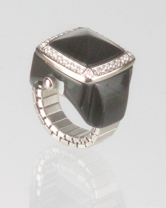 Amazing unique KJL (Kenneth Jay Lane)ring watch featuring a flip-top set with a black onyx, surrounded by cubic zirconium crystals. Black enamel shoulders. Expandable shank, suitable for various ring sizes. Marked on back cover:
KJL STAINLESS STEEL