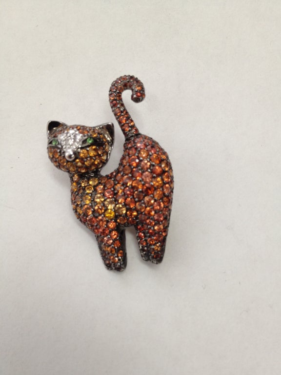 Adorable 14k white gold Estate Kitty cat Pin Brooch, encrusted with Orange Sapphires and Diamonds; Emerald Eyes Approx. Size: 1 ½ x ¾ Marked: d'oro 585 (European standard for 14k) & maker's mark. Circa: 1980s
Excellent vintage condition