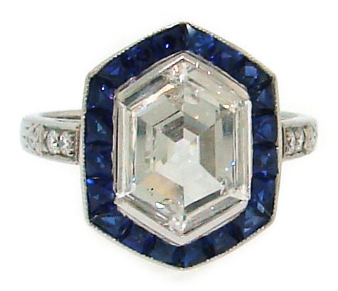 Ein ungewöhnlicher Diamant im Rosenschliff in sechseckiger Form:: umrahmt von Saphiren im französischen Schliff und gefasst in einem Verlobungsring aus Platin:: der in den 1910er Jahren in Europa entstand. 
Der Diamant im Sechseckschliff misst 10::6