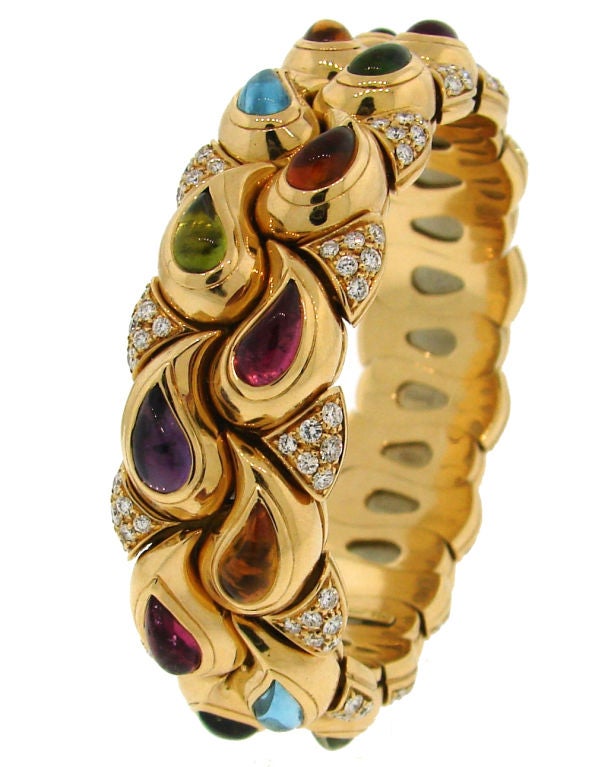 Colorful and chic bangle created by Chopard. It is made of yellow gold and set with round diamonds, tear-drop shape amethyst, peridot, citrine, aquamarine and pink tourmaline.<br />
Fits up to 6.5