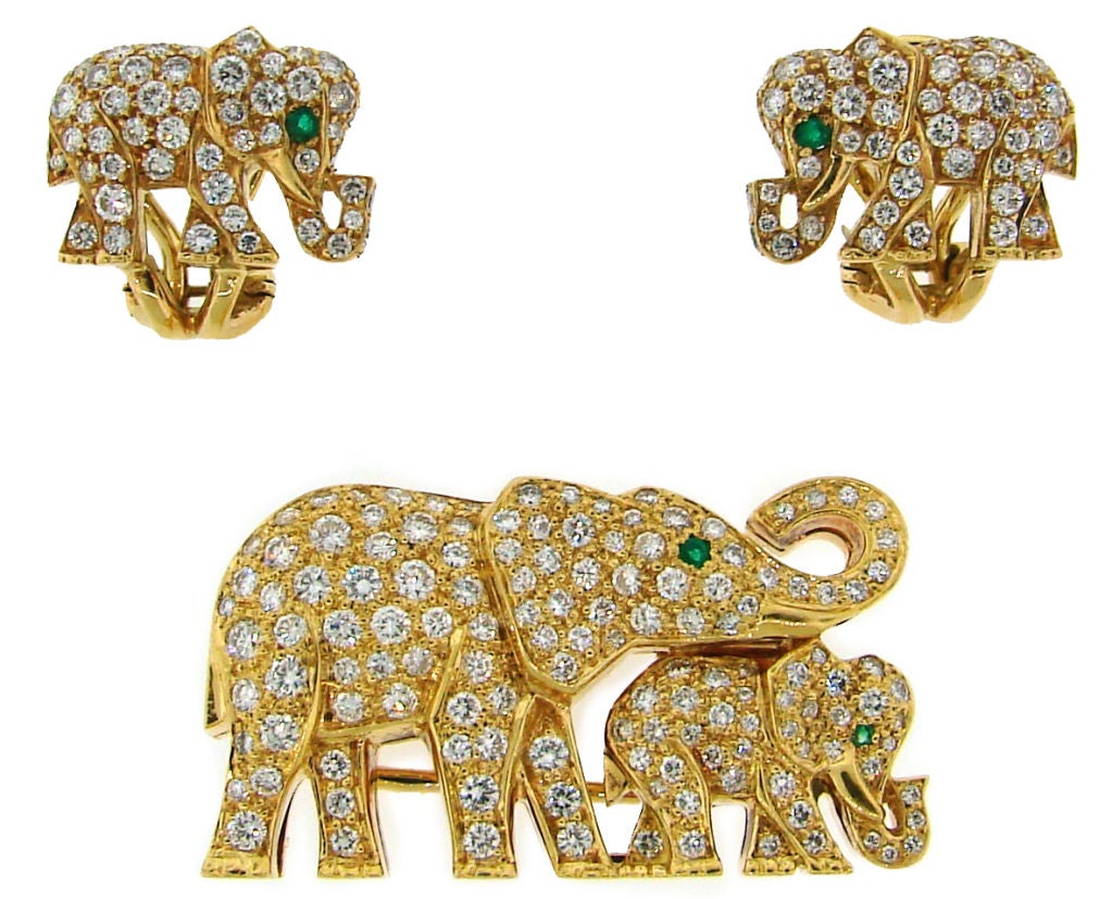 Lovely elephant set consisting of a brooch and earrings created by Cartier in France in the 1980's. The set is made of yellow gold and pave-set with diamonds. Emeralds accentuate the elephants' eyes.<br />
The brooch measures slightly under 1-1/4