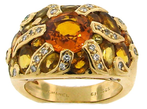 Chic and sunny ring created by Chanel. Features an orange sapphire in the center accentuated with yellow sapphires and diamonds set in yellow gold.
The ring is size 6.5; it can be sized if needed.