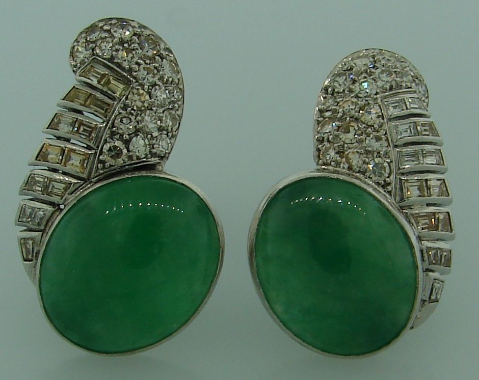 Stilvolle Art-Déco-Ohrclips aus den 1930er Jahren. Das Highlight der Ohrringe sind ovale Knöpfe aus grüner Jade, die geschmackvoll mit Diamanten im Einzel- und Baguetteschliff (Gesamtgewicht ca. 0,80 Karat) akzentuiert sind. Die Ohrringe sind aus
