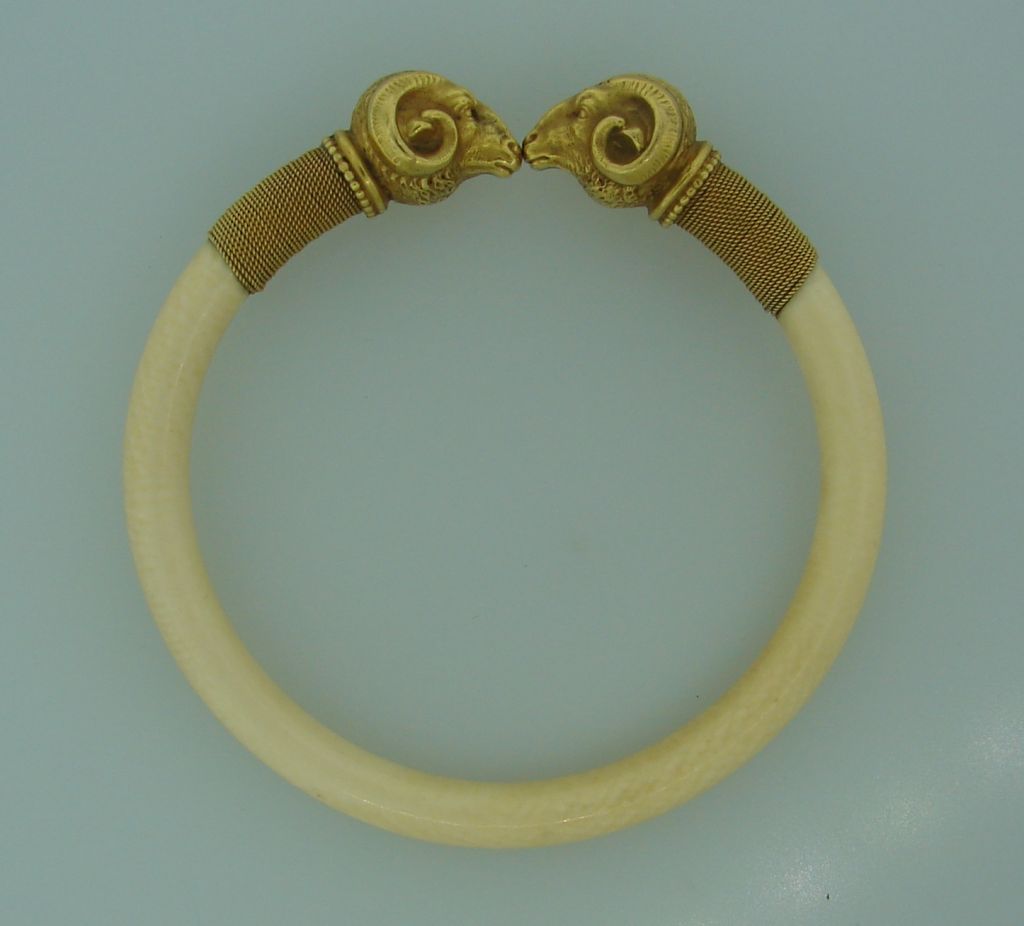 Stunning bangle depicting two ram heads facing each other made of bone and yellow gold.<br />
There are French hallmarks.<br />
Inner diameter 2-5/8