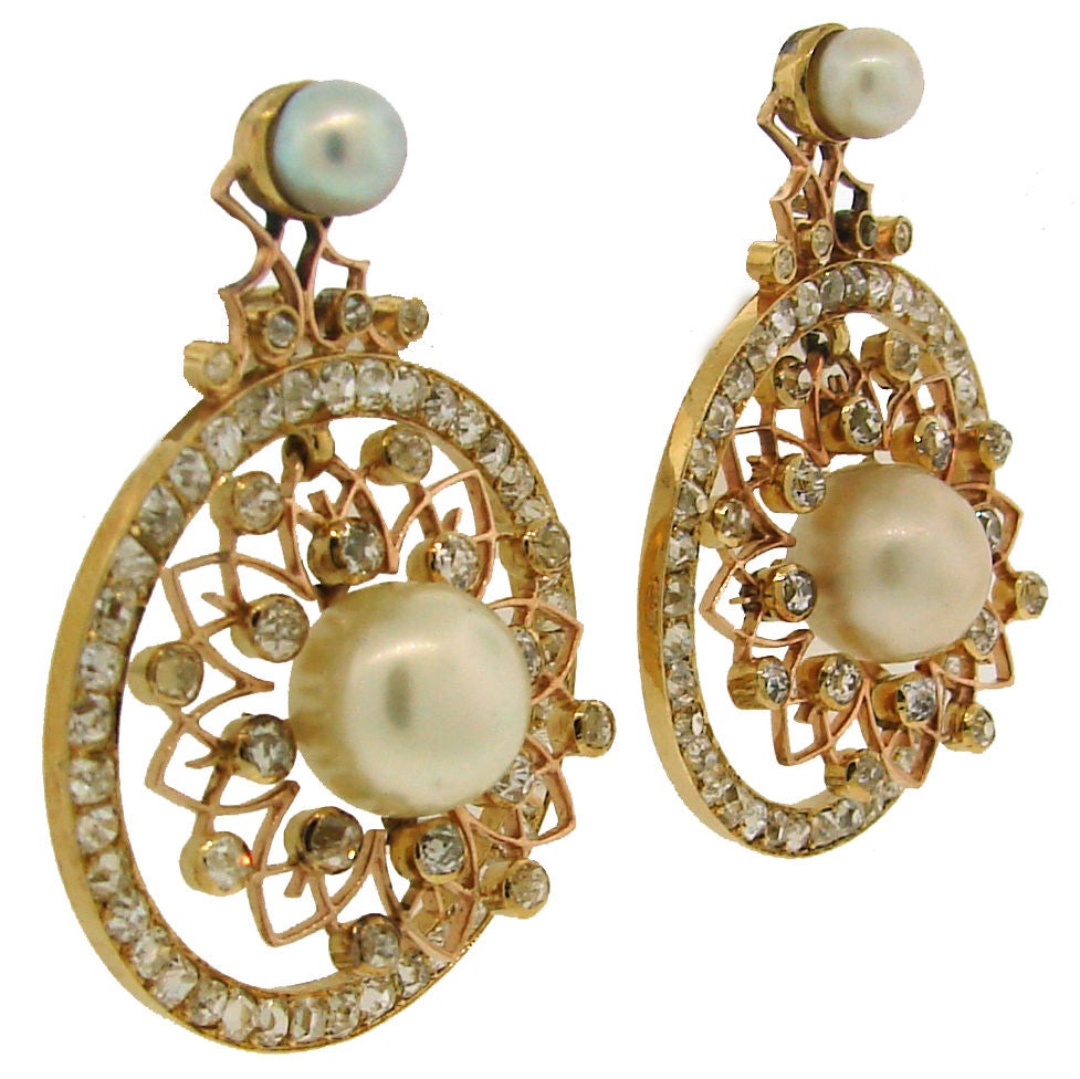 Elegant and delicate open-work earrings created in Europe in the 1900's. White pearls and old cushion cut diamonds set in yellow gold are creating beautiful shimmering look.<br />
The bottom pearls are 10.0 mm in diameter, the top ones - 5.4 mm.