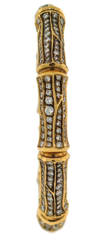 Stunning bangle from Bamboo Collection created by Cartier in the 1980's. It is made of yellow gold and studded with round diamonds.<br />
Fits up to 6.5