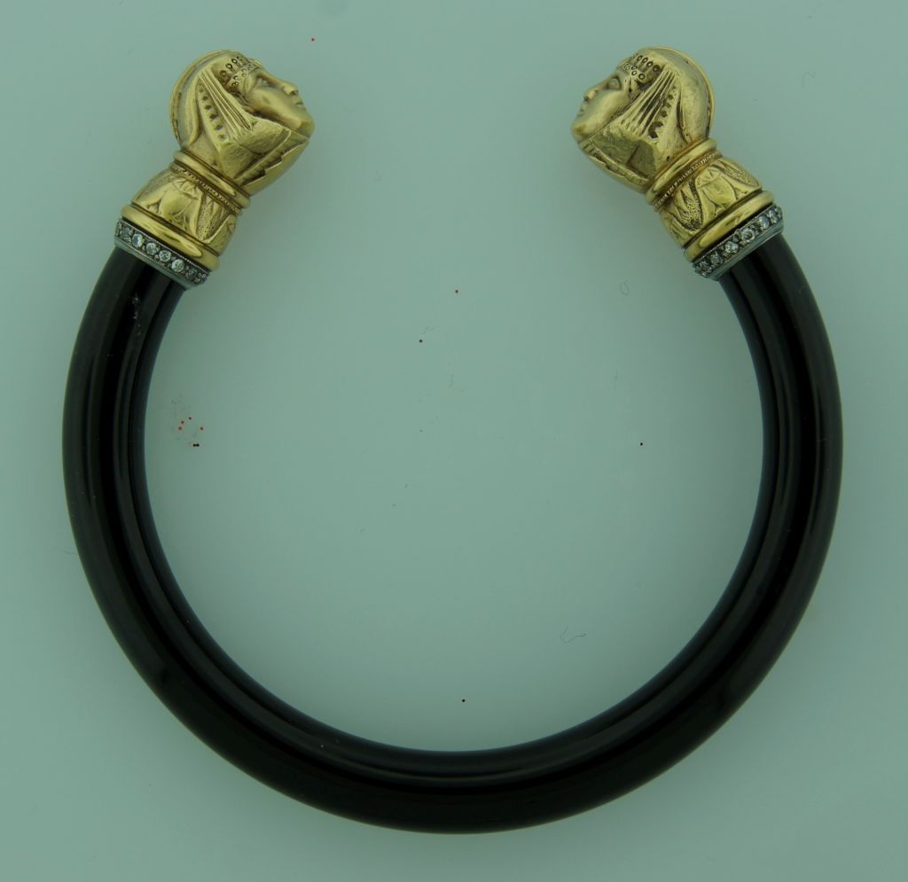 Stunning Art Nouveau Egyptian Revival bangle created in Europe in the 1910 - 1930's. It features two yellow gold sphinx heads accentuated with diamonds facing each other and ending a black onyx bangle.
Inner diameter is 2.5 inches (6.4 cm), outer
