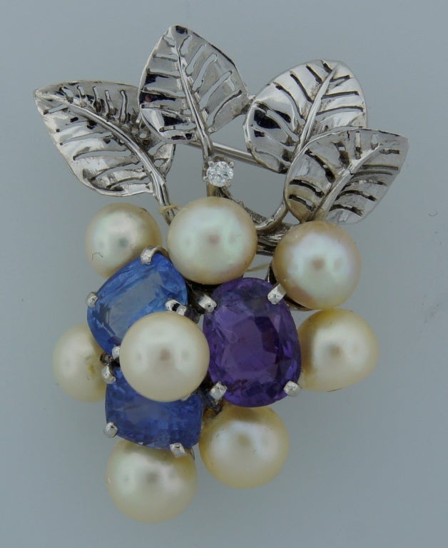 Lovely brooch created in the 1960's by Seaman Schepps, who often found his inspiration in Nature. Design of this tastefully made piece was inspired by floral motifs. The brooch is made of 14k white gold and features three cushion cut sapphires and