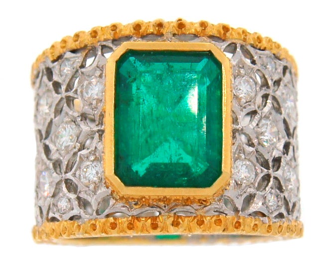 Stunning signature Mario Buccellati ring created in Italy in the 1960s. It features an approximately 2.09-ct Colombian emerald framed in openwork two-tone 18 karat gold studded with twenty six round diamonds. Ring is size 6, 5/8 inch (15.7 mm) wide