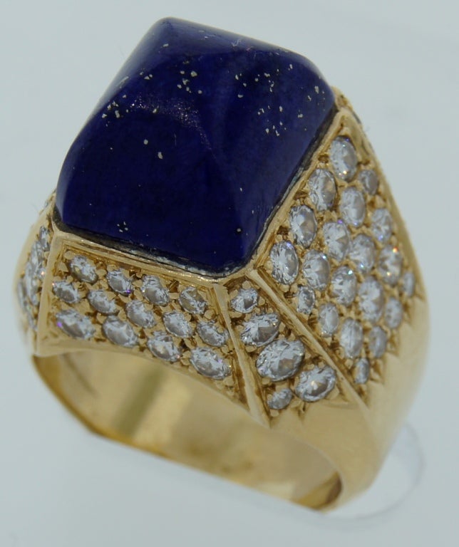 Colorful and prominent vintage cocktail ring created in France in the 1970's. It features curved pyramid shape lapis lazuli set to the top of the ring and accentuated with round diamonds. The setting is made of 18k yellow gold. It is a very nice