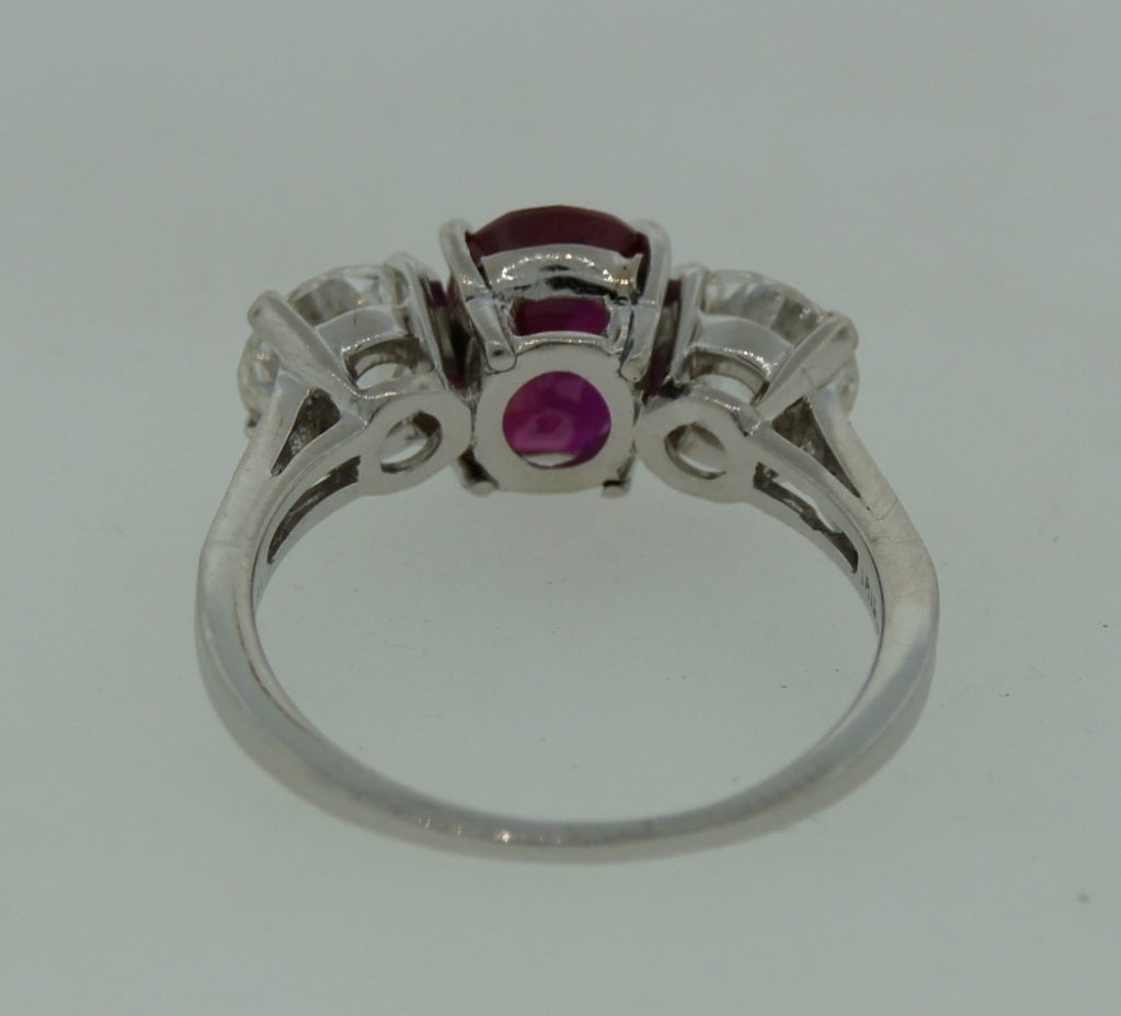 Elegant and timeless three-stone ring that symbolizes Past, Present and Future. Created by Tiffany & Co. in the 1970s. Features an exceptional 2.20-ct oval mixed cut Burmese ruby. It is accompanied with an American Gemological Lab (AGL) Gemstone