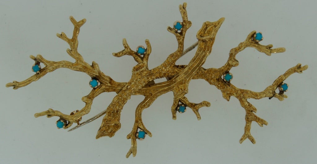 Mysterious stylized brunch pin created by Cartier in Italy in the 1980's. Made of yellow gold with little turquoise berries.
