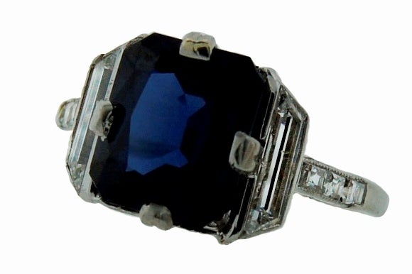 Amazing Art Deco ring created by Cartier in the 1930's. Features a modified cushion cut sapphire flanked with trapeze diamonds and accented with three emerald cut diamonds on each side. Setting is made of platinum.
Cartier maker's mark and serial