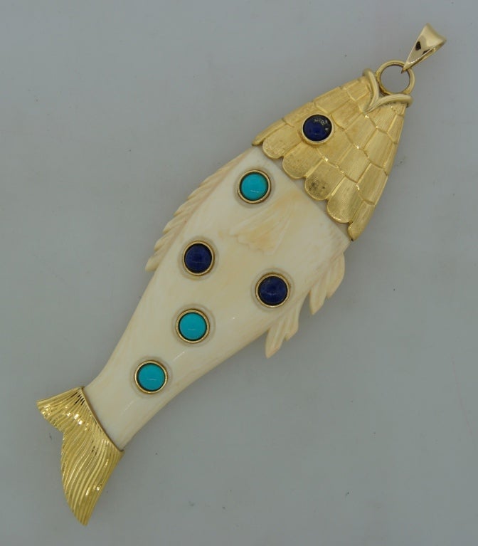 Cute and fun fish pendant created by Cartier in the 1970's. Made of ivory, yellow gold and accented with turquoise and lapis lazuli. Definitely is a conversational piece.
Has a Cartier maker's mark, serial number and hallmark for 18 gold.