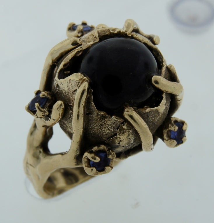 Unusual ring with whimsical design that would definitely get attention! It features a star black sapphire set in yellow gold and accented with blue sapphires. 
Size 7.25. It can be sized if needed.