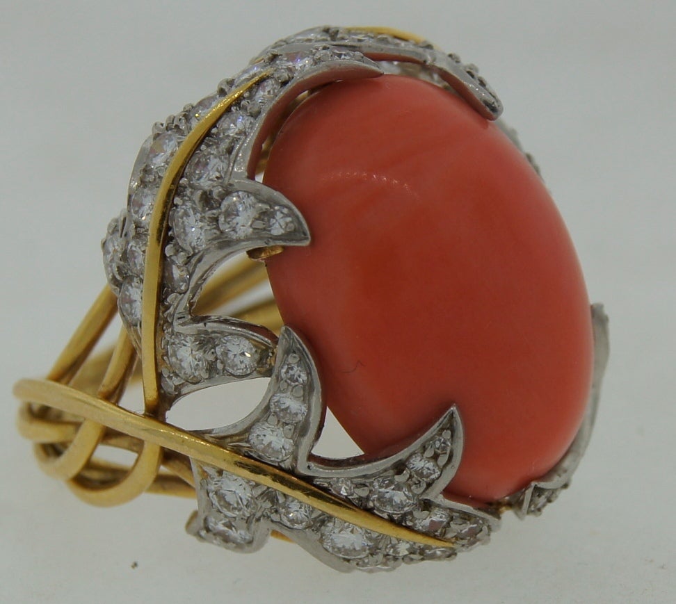 Stunning colorful cocktail ring created by David Webb in the 1970's. Features an oval coral accented with diamonds set in platinum and yellow gold. 
Ring size is 5 - 5.5; can be re-sized if needed.
Great summer ring! Wearable and chic!
