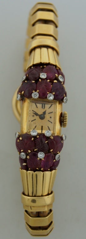 Fabulous lady's Retro bracelet watch created by Van Cleef & Arpels in the 1940s. Features carved rubies accented with diamonds set in yellow gold. Chic and feminine. 
The watch fits up to 6-1/4