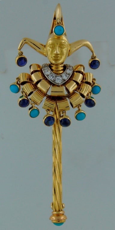 Adorable and fun Jester pin created by Cartier in the 1950's. 
Beautiful color combination of light blue turquoise, blue sapphire white diamonds and yellow gold.
The pin is signed and numbered and comes in the original Cartier box.