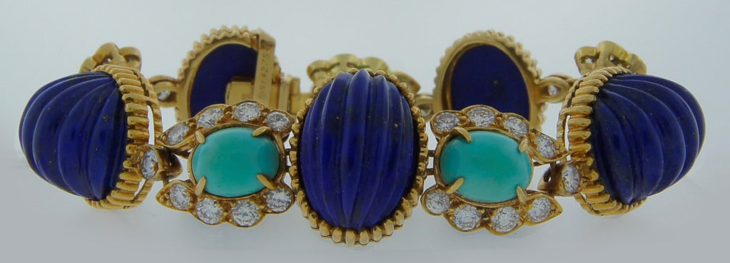 Colorful and stylish vintage bracelet created by Van Cleef & Arpelsin New York in the 1970's. Features five carved lapis lazuli alternating with five oval turquoise cabochons set in yellow gold and accented with round brilliant cut diamonds.
The