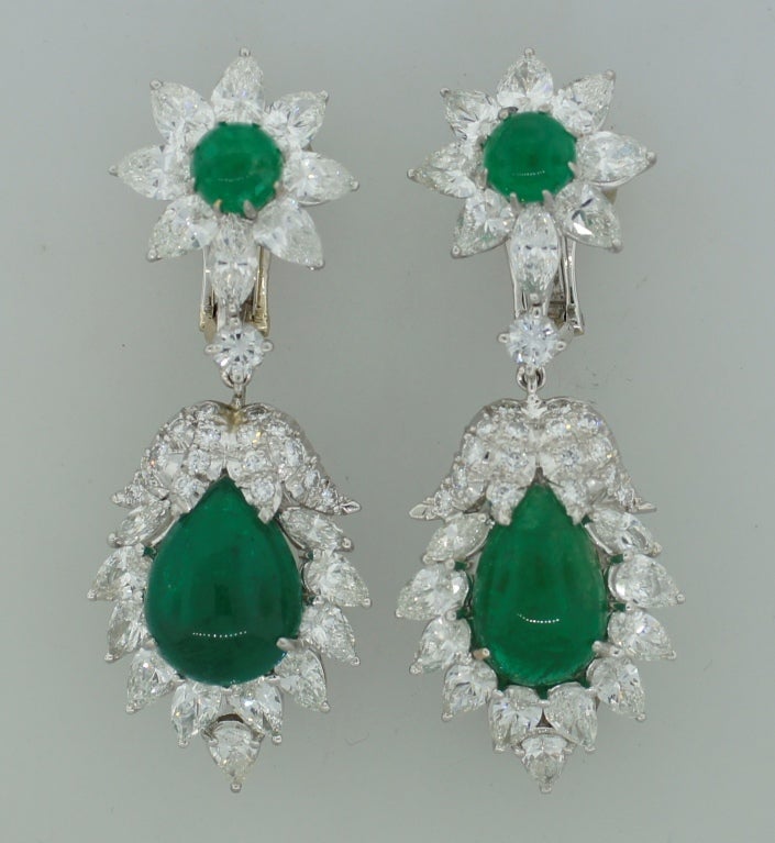 Stunning interchangeable earrings created by David Webb in the 1970's. Feature cabochon emeralds surrounded with diamonds set in platinum. 
The emeralds are - pear-shape approximately 5.56-ct and 7.51-ct, round - 1.20-ct each, total weight 15.47