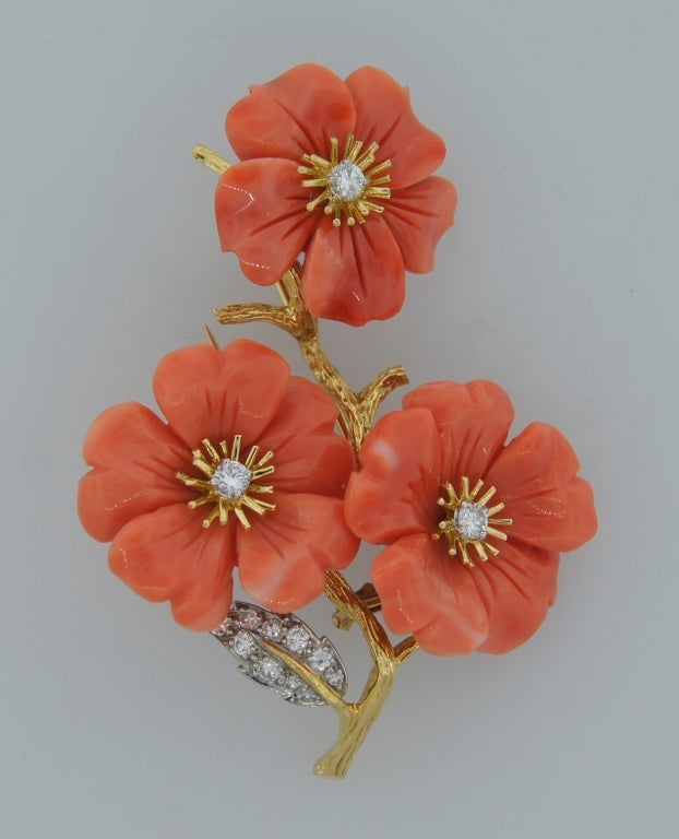 Sweet and feminine brooch created by Boucheron, Paris in the 1960's. Inspired by nature, and flower motifs, the pin features a stem with three beautiful flowers made of carved coral and accented with round diamonds.
The flowers are 1