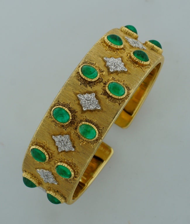 : Famous signature Buccellati bangle created in Italy in the 1960's. The highlights of this bracelet are typical Buccellati satin finish on gold and twelve oval cabochon emeralds bezel set in tastefully engraved yellow gold frames. The emeralds