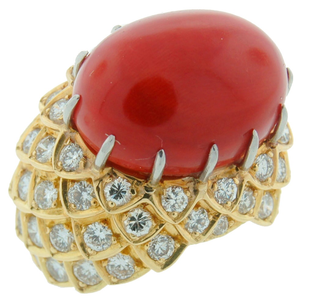 Stunning bold and colorful ring created by David Webb in the 1980's. Elegant and chic!
Features an elegant oval cabochon coral set in yellow gold studded with round brilliant cut diamonds. Diamond total weight 4.0 carats, the coral measures 19.21 x