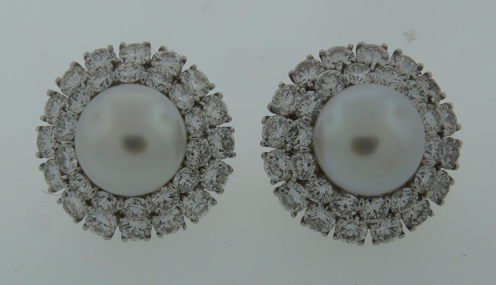Exquisite dressy earrings created by Harry Winston. Feature a beautiful white South Sea button pearl surrounded with two rows of finest diamonds set in platinum. The pearls are 13.5 mm in diameter. The diamonds are round brilliant cut of E-F color,
