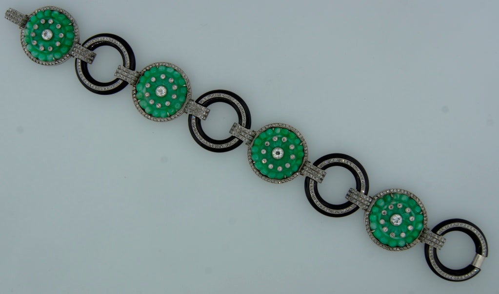 Elegant and understated bracelet created in the 1910s. Tastefully carved jade discs alternate with black onyx circles, all accented with diamonds. Geometrical sharp design. Beautiful color combination and outstanding workmanship!
The bracelet is