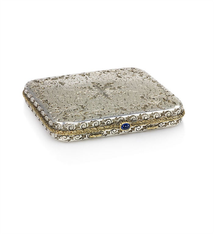 An engraved compact of foliate design, with gold ropetwist trim and a cabochon sapphire, in sterling silver. M. Buccellati, Italy.