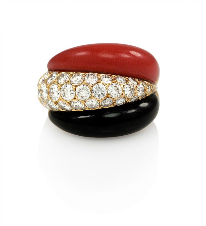 A ring comprised of three tiers of juxtaposed bombé onyx, coral, and pave diamond sections, in 18k gold. 
Van Cleef & Arpels, Paris.
 #B5126-I-68.
